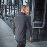M-Tac Delta Polartec -fleece-takki harmaana, nähtynä takaa miehellä kaupunkimaisemassa.