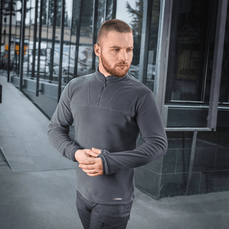 Mies pukeutuneena M-Tac Delta Polartec -fleece-takkiin kaupunkiympäristössä.