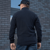 M-Tac Delta Polartec -fleece-takki nähtynä takaa, Polartec® Micro Series -fleecestä, kaupunkitaustalla.