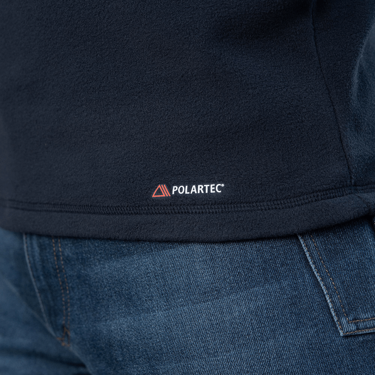 Lähikuva M-Tac Delta Polartec -fleece-takista, Polartec® Micro Series -fleecestä ja hillitty Polartec-logo saumassa.