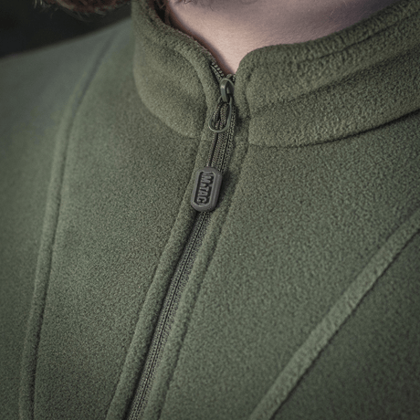 Lähikuva M-Tac Delta Polartec fleece-takista vihreänä, näyttää vetoketjen ja kangasrakenteen yksityiskohtia, valmistettu Polartec® Micro Series -fleecestä.