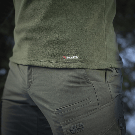 Vihreä M-Tac Delta Polartec fleece-takki, näkyvissä Polartec-logo, valmistettu kulutusta kestävästä ja hengittävästä materiaalista.