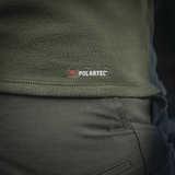 Lähikuva M-Tac Delta Polartec fleece-takista oliivinvihreänä, näkyy Polartec-logo ja kestävä, hengittävä Polartec® Micro Series -fleece.
