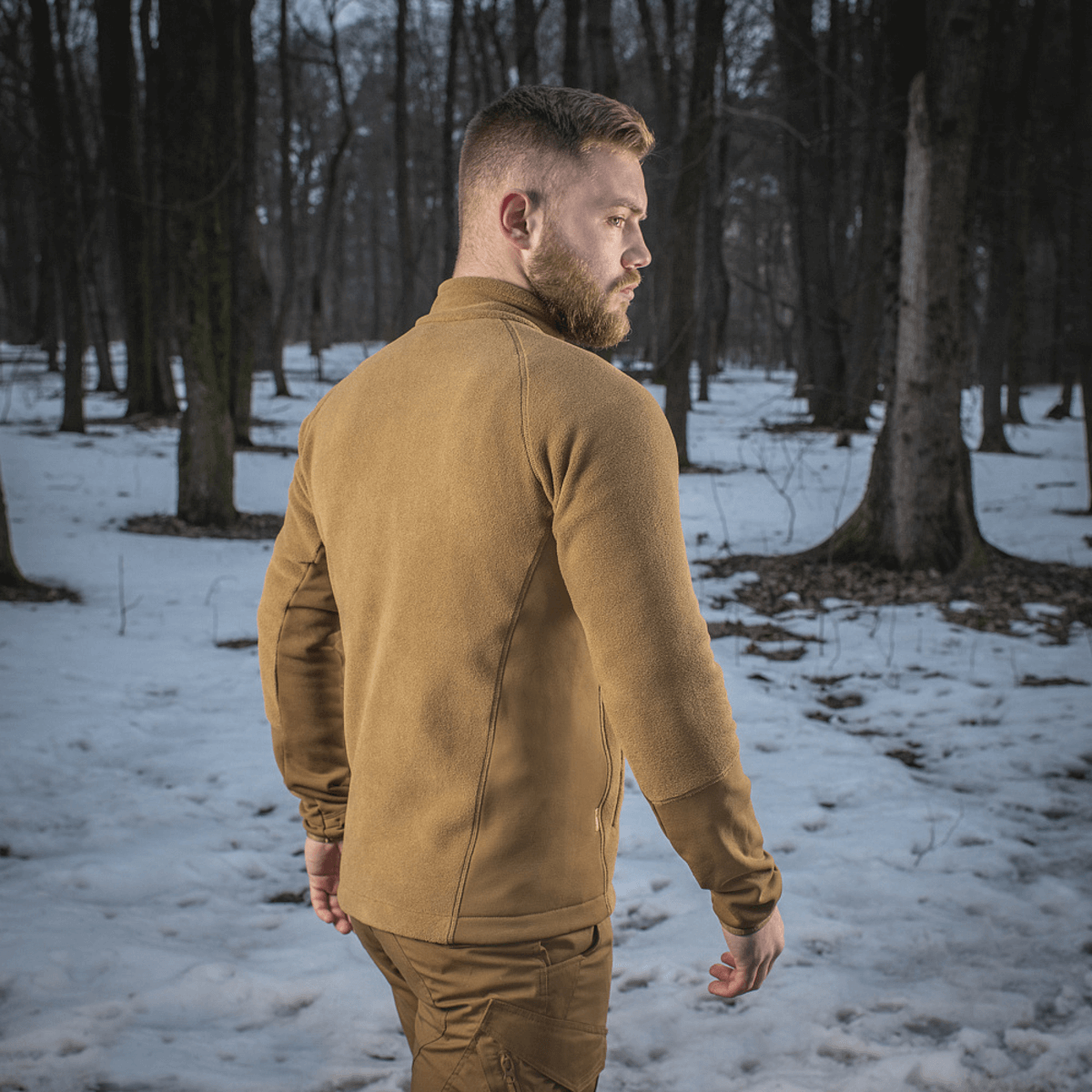 M-Tac Polartec Sport -fleecatakki lumisessa metsässä, sopii ulko- tai välikerrokseksi lämmön ja mukavuuden saavuttamiseksi.