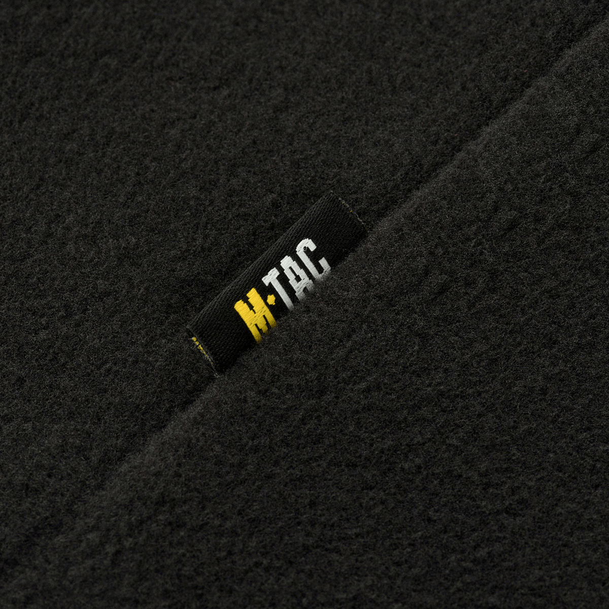 Lähikuva M-Tac Delta Polartec -naisten fleecetakista, musta M-Tac-logo kestävässä Polartec® Micro Series -fleecessä.
