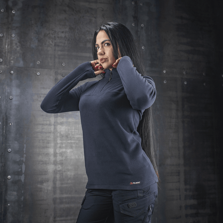 Nainen pukeutuneena M-Tac Delta Polartec -naisten fleece-takkiin tummansinisenä, valmistettu Polartec® Micro Series -fleecestä mukavuutta ja lämpöä varten.