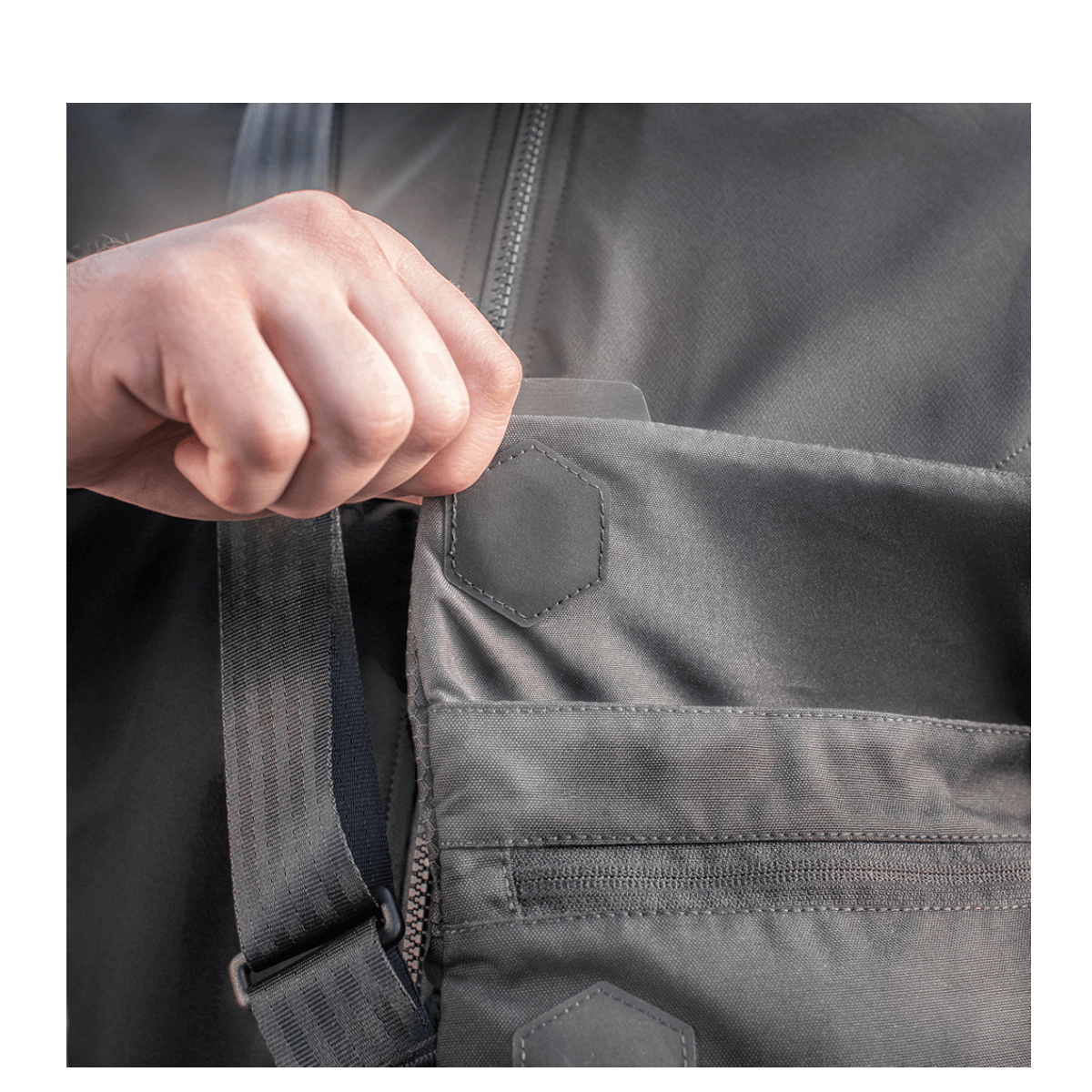 Käsi avaa taskun M-Tac Konvert Taske Elite -laukusta, valmistettu Cordura-materiaalista, magnetventil-avaus.