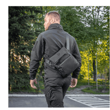 Mies käyttää M-Tac Konvert Taske Eliteä metsäympäristössä.