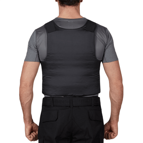 Mies pukeutuneena Anorak Topaz® Concealable II -pistosuojaliiviin takaa, näyttää piilotettavan ja turvallisen istuvuuden.
