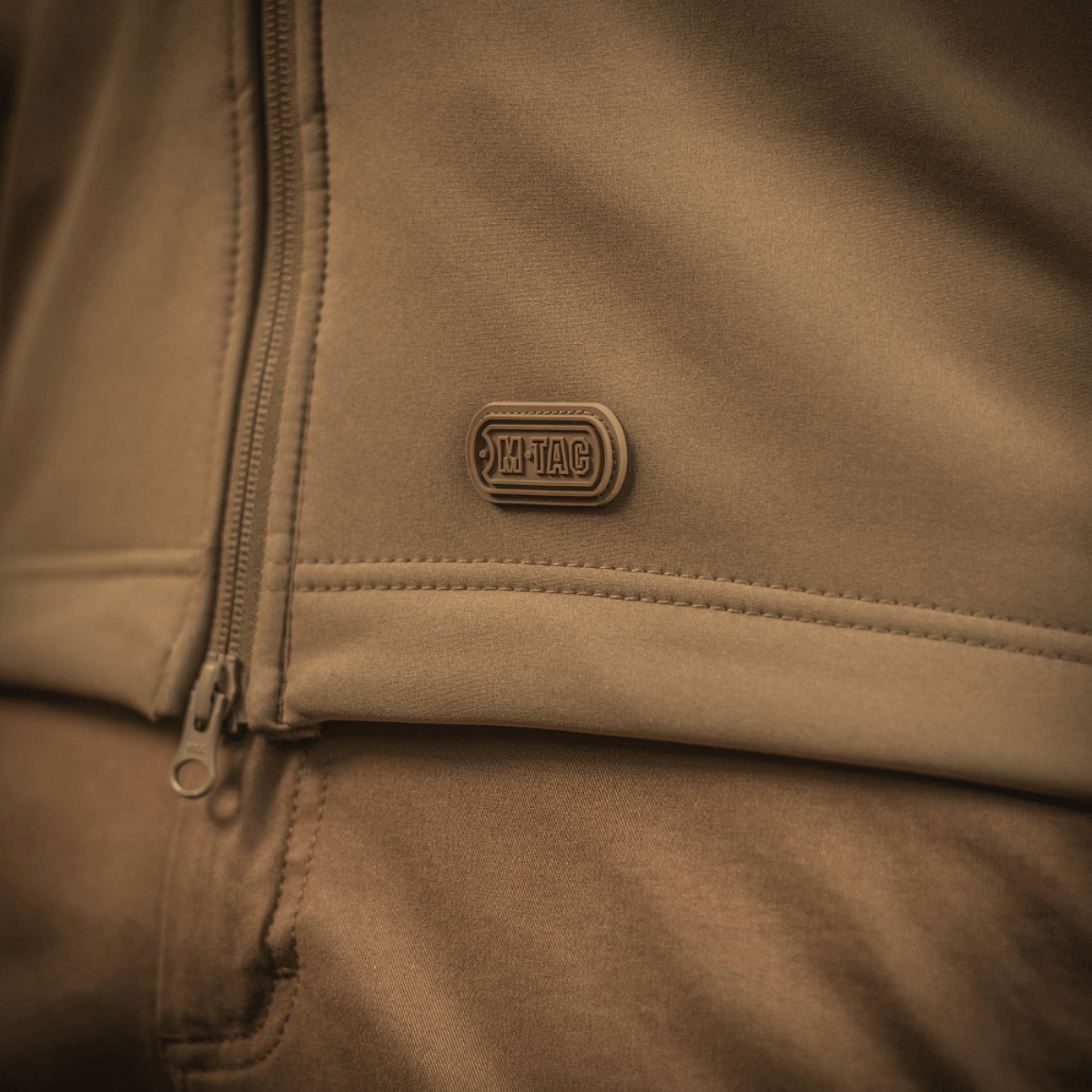 Lähikuva M-Tac Soft Shell -takista, korostaa kevyttä muotoilua polyuretaanikalvolla ja fleece-vuorella sääsuojaukseen.