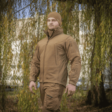 Mies pukeutuneena M-Tac Soft Shell -takkiin luonnonympäristössä.
