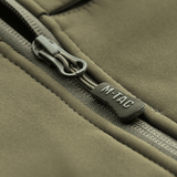 Lähikuva vetoketjusta M-Tac Soft Shell Police Jakkeessa, jossa M-Tac‑logo, suunniteltu tuulta ja säätä vastaan.