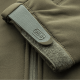 Lähikuva M-Tac Soft Shell Police Jakkeesta beigeenä, näyttää vetoketjun ja hihan tarrakiinnityksen.