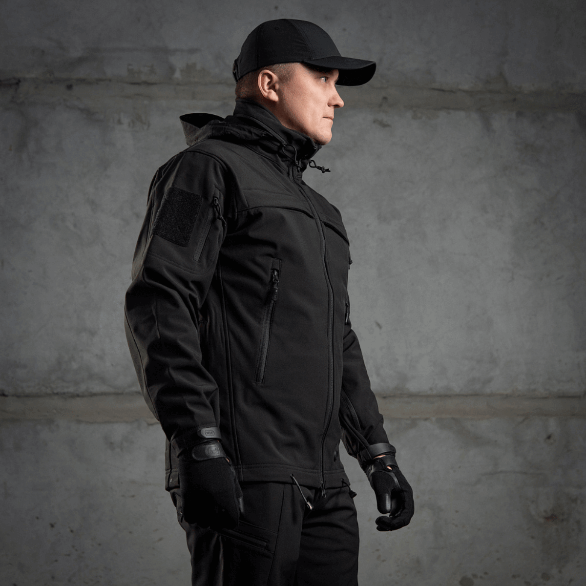 M-Tac Soft Shell Police Jakke mustana, suunniteltu tuulta vastaan polyuretaanikalvolla ja fleecellä, dynaaminen leikkaus ja säädettävät tunnistepaneelit.