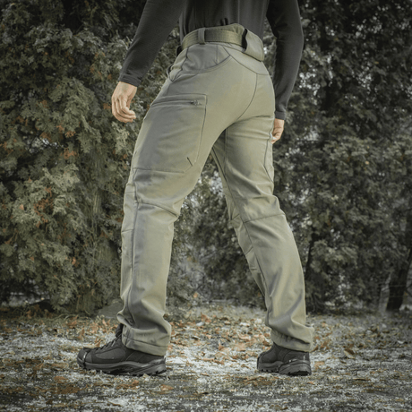 M-Tac Soft Shell Vinter -housut metsäympäristössä, korostaa housujen lämpöä ja mukavuutta kylmissä, tuulisissa olosuhteissa.