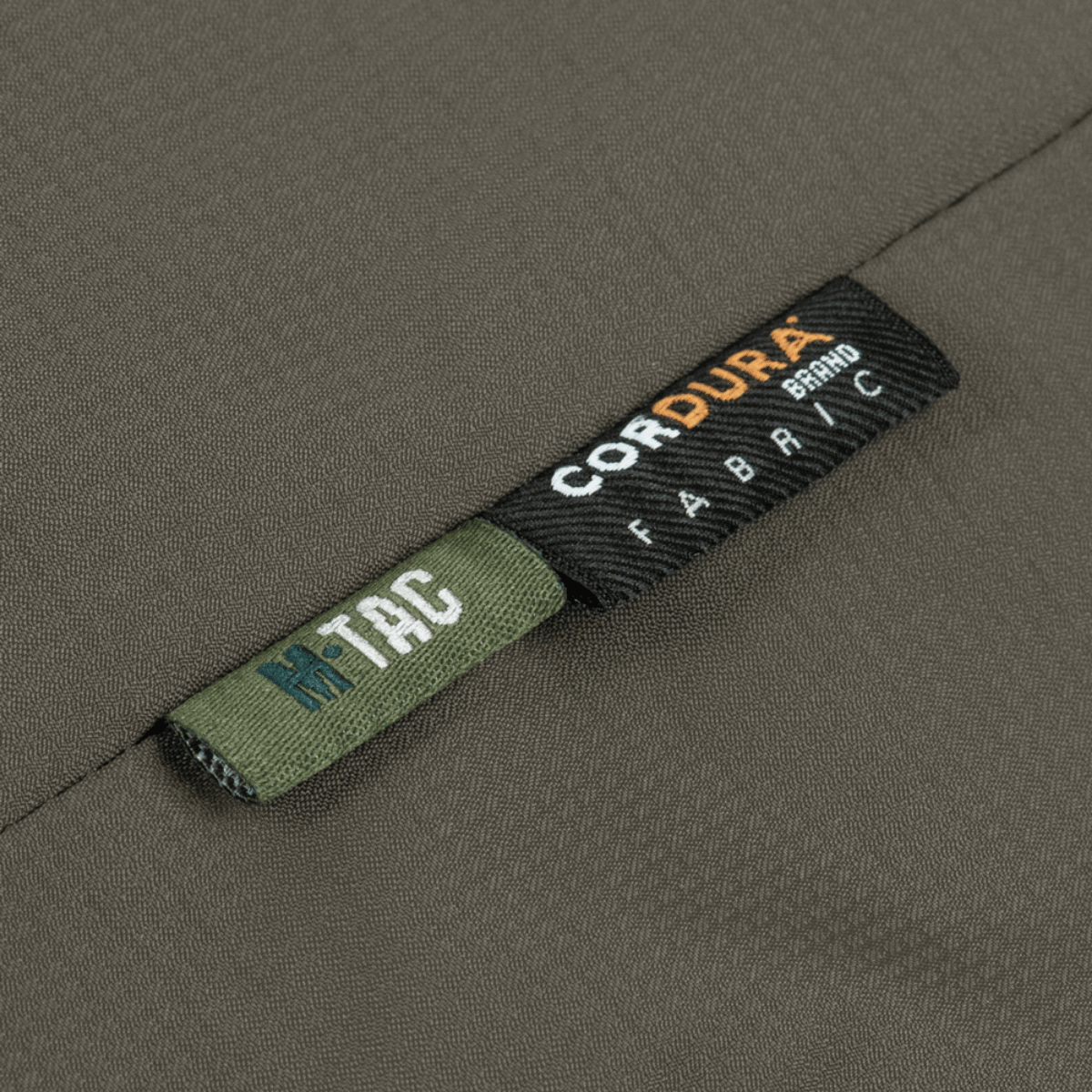 M-Tac Alpha Gen.III Pro -talvitakin etiketti Cordura-kankaasta, osoittaa kestävyyttä ja laatua, sopii äärimmäisiin olosuhteisiin.