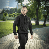 Mies M-Tac Cotton Raglan -hupparissa puistossa, korostaa mukavuutta ja tyyliä arkeen ja aktiiviseen käyttöön.