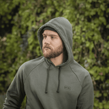 Mies M-Tac Cotton Raglan -hupparissa ulkoilmassa vihreässä ympäristössä.