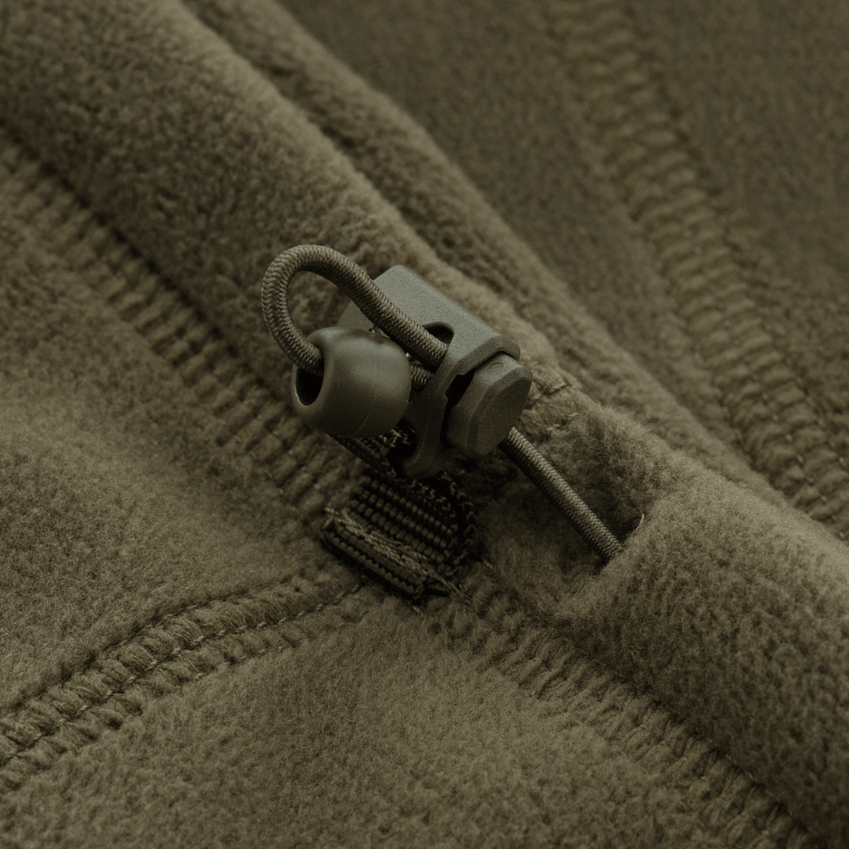 Yksityiskohta M-Tac anatomisesta Tube Scarfista narulla Polartec, valmistettu pehmeästä Polartec Micro Series -fleecestä, korostaa sulkumekanismia