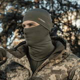 Henkilö käyttää M-Tac Tube Scarf Polartec Power Grid -kauluria metsäympäristössä, suojaa tuulelta ja kylmältä, monikäyttöinen kauluri ja kasvomaskina.