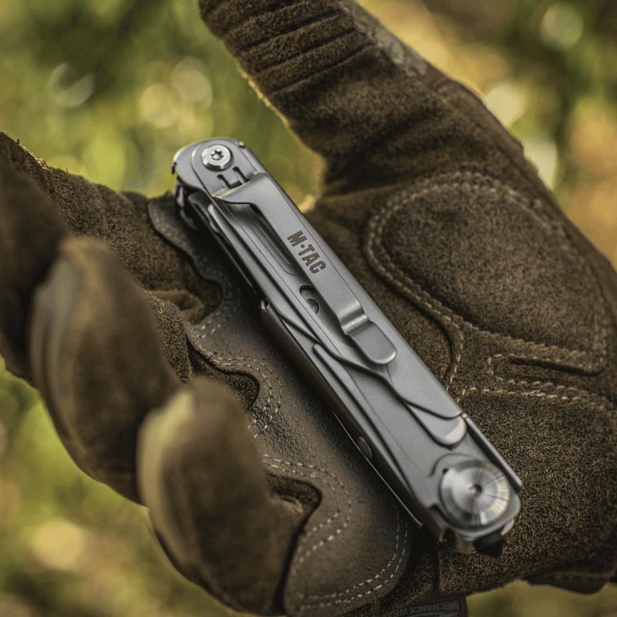 M-Tac Type 3 Foldekniv (5-i-1) Rustfrit Stål hanskat kädessä, sopii EDC‑käyttöön monipuolisilla työkaluilla päivittäisessä ja ulkokäytössä.