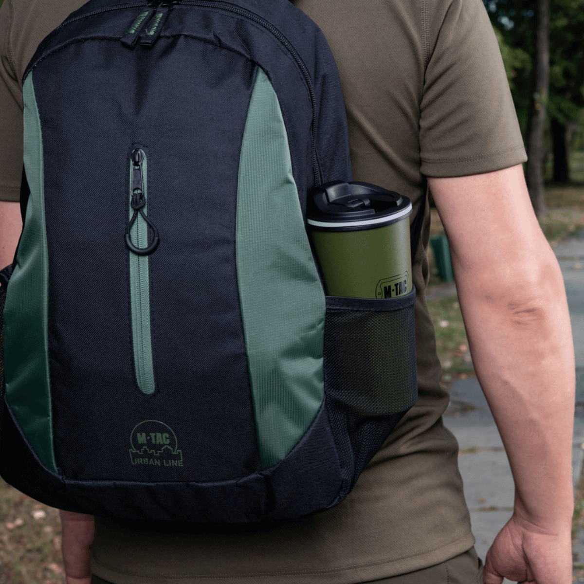Mies repun kanssa, jossa on M-Tac 450 ml termosmuki venttiilillä, sopii kuumiin ja kylmiin juomiin liikkeellä
