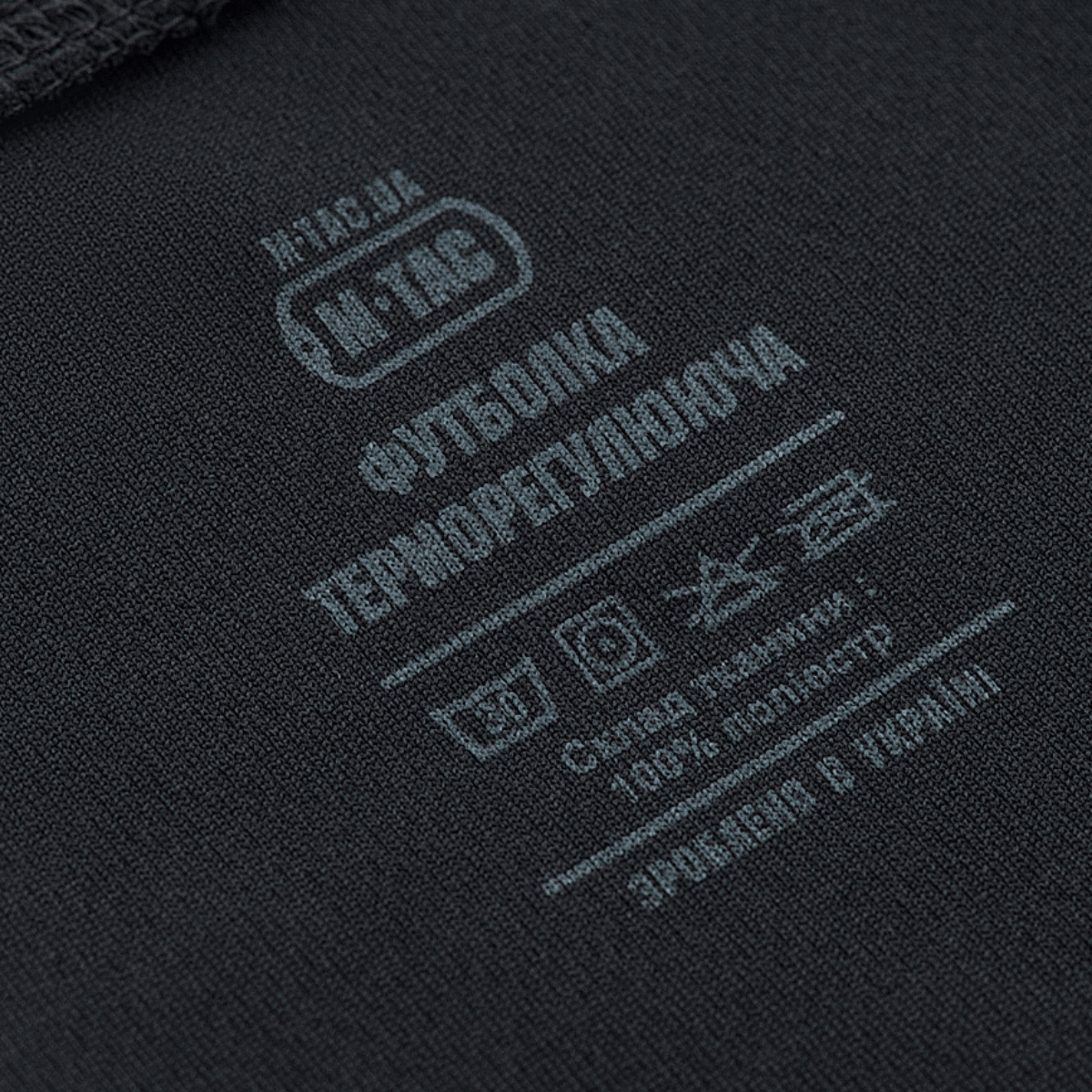 M-Tac Sweat-Wicking T-Shirt Gen.II etiketti pesuohjeineen ja 100% polyesterikokoonpanolla, lähikuva.