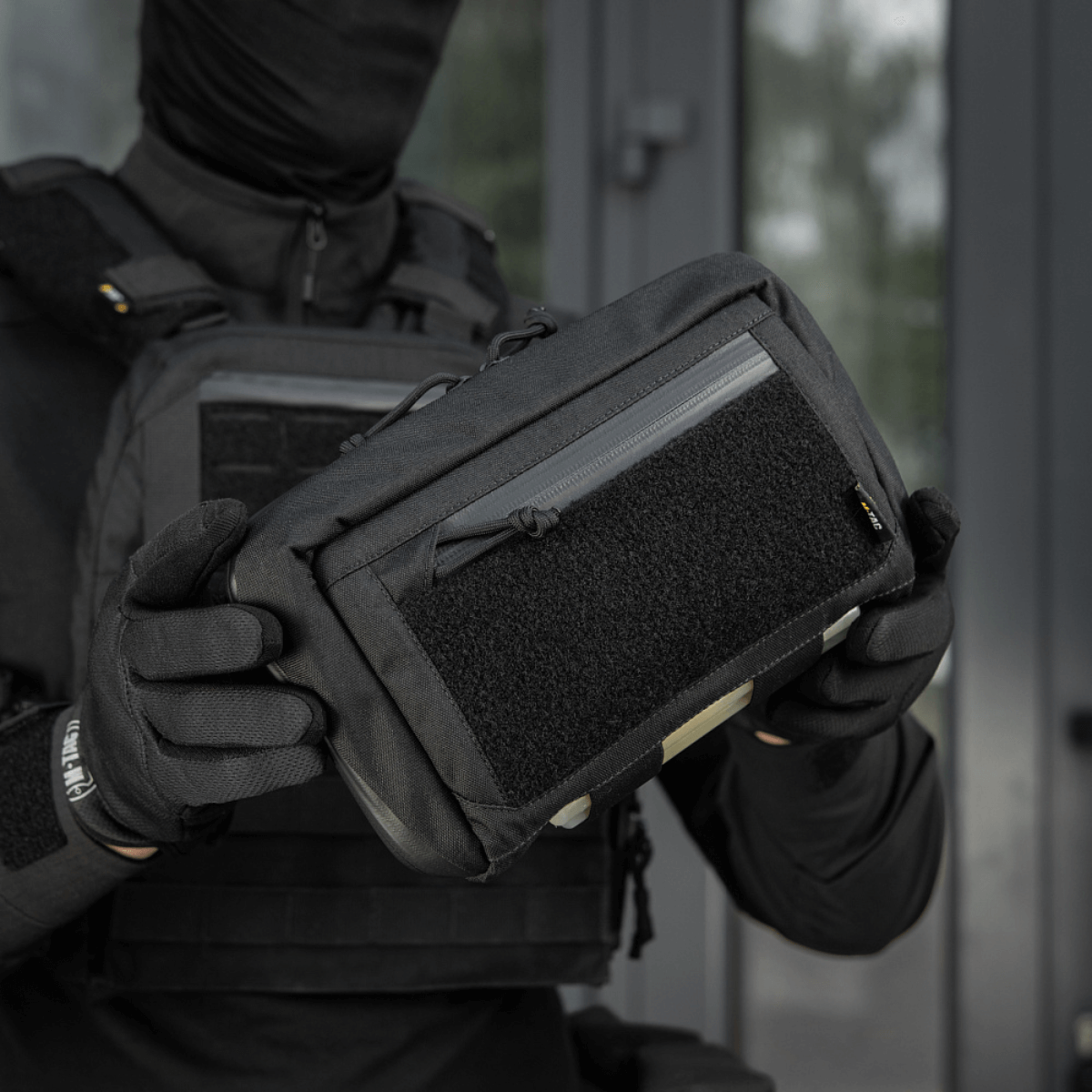 Henkilö pitää M-Tac Admin Pouch Large Elite Gen.II:ta; suunniteltu säilytykseen modulaarisilla lisävarusteilla ja Cordura 500D -materiaalilla.