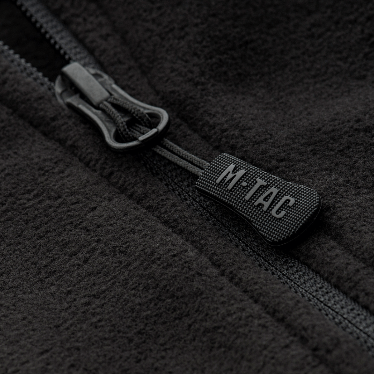 Lähikuva M-Tac Delta Fleece -takin vetoketjusta, näyttää mustan fleece-kankaan ja vetoketjudetaljit, ihanteellinen ulkokäyttöön kylmässä säässä