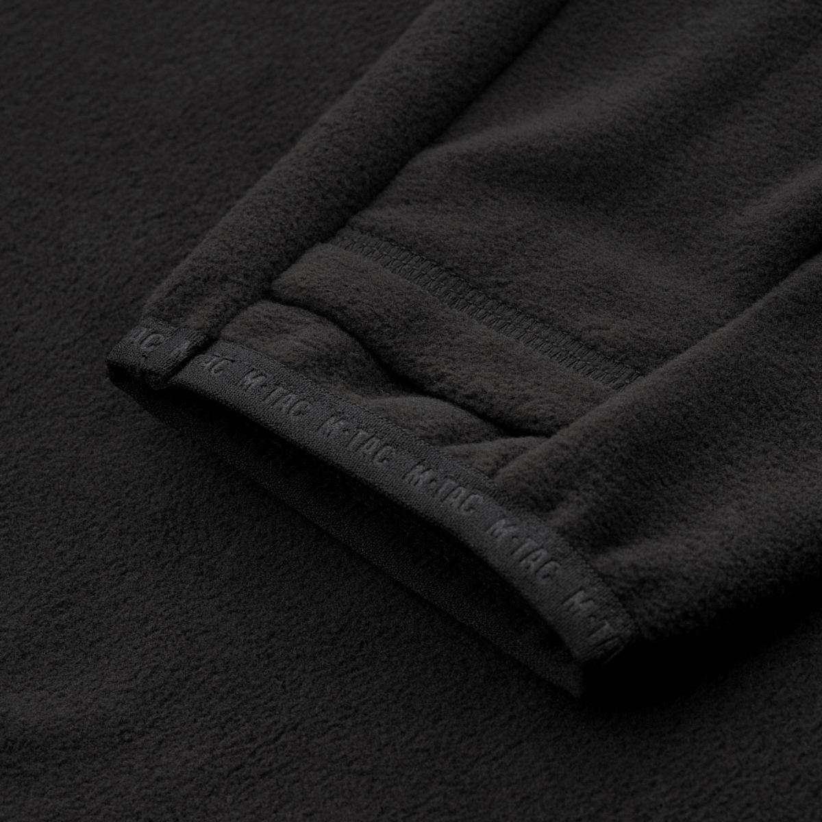 Yksityiskohta M-Tac Delta Fleece -takista peukalonrei'illä. Ihanteellinen ulkoiluun kylmässä säässä. Materiaali: fleece 190 g/m²