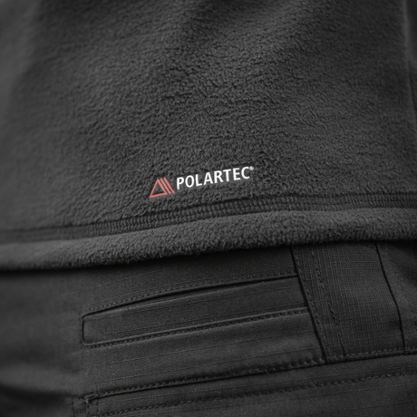 Yksityiskohta M-Tac Delta Polartec Raglan -takista, tehty Polartec-fleecestä Polartec-logolla.