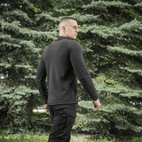 Mies pukeutuneena M-Tac Delta Polartec Raglan -takkiin mustana, miellyttävä ja lämmin fleece, sopiva ulkoilukäyttöön.