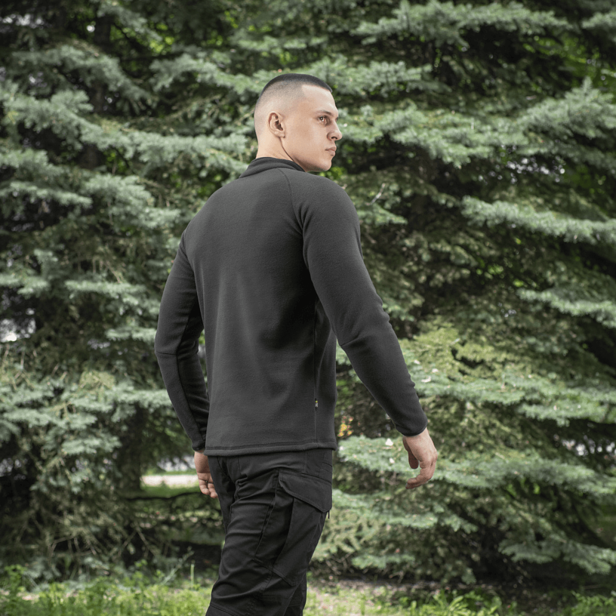 Mies pukeutuneena M-Tac Delta Polartec Raglan -takkiin mustana, miellyttävä ja lämmin fleece, sopiva ulkoilukäyttöön.