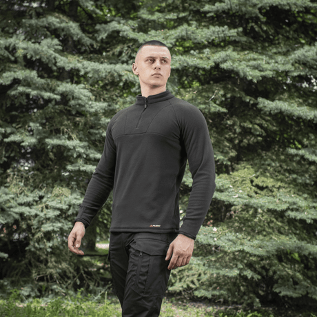 Mies pukeutuneena M-Tac Delta Polartec Raglan -takkiin luonnossa, sopiva ulkoiluun ja jokapäiväiseen käyttöön, Polartec® Micro Series -fleecellä.
