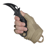 Käsi, joka kantaa M-Tac sormettomia Assault Tactical Mk.4 -käsineitä ja pitää veistä tiukassa otteessa.
