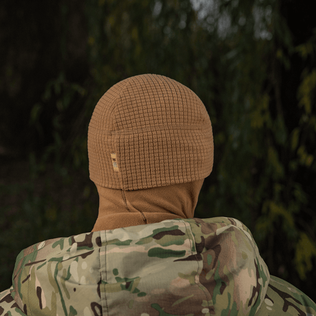 M-Tac Rip-Stop Fleece Hjelmliner luonnonympäristössä maastokuvioisen takin kanssa, sopii kylmiin olosuhteisiin