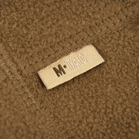Lähikuva M-Tac Fleece Neck Gaiter med Snor, näyttää pehmeän fleecemateriaalin ja merkkietiketin.