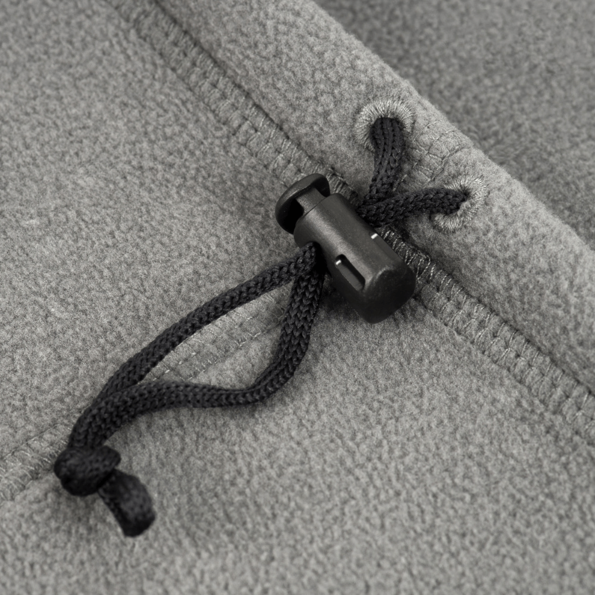 Yksityiskohta M-Tac Fleece Neck Gaiter med Snor harmaasta fleecestä ja mustasta säätönyöristä.
