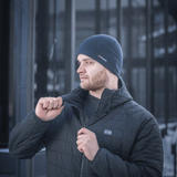 Mies pukeutunut M-Tac Fleece Watch Cap Light Polartec talvihattu, seisoo ulkona kylmässä säässä en lämmin takki yllä
