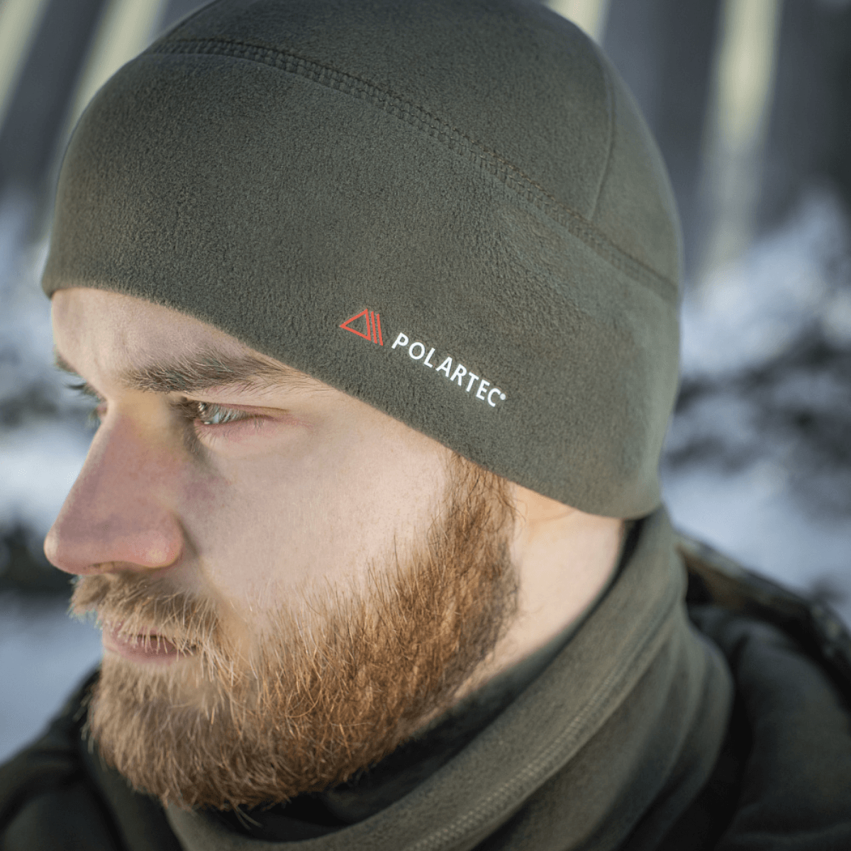 Mies pukeutuneena M-Tac Fleece Watch Cap Light Polartec -pipoon talvisessa ympäristössä.