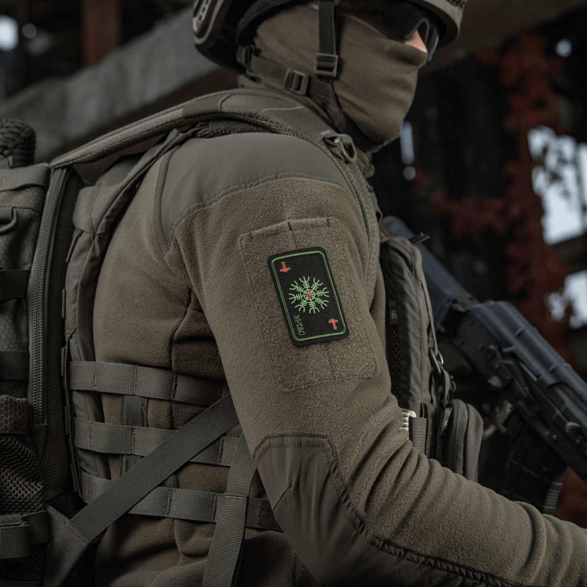 Sotilas M-Tac Patch Kort Helm of Horror (brodeerattu) kiinnitettynä takkiin, brodeerattu Ægishjálmur-symboli, Cordura 500D -materiaali.
