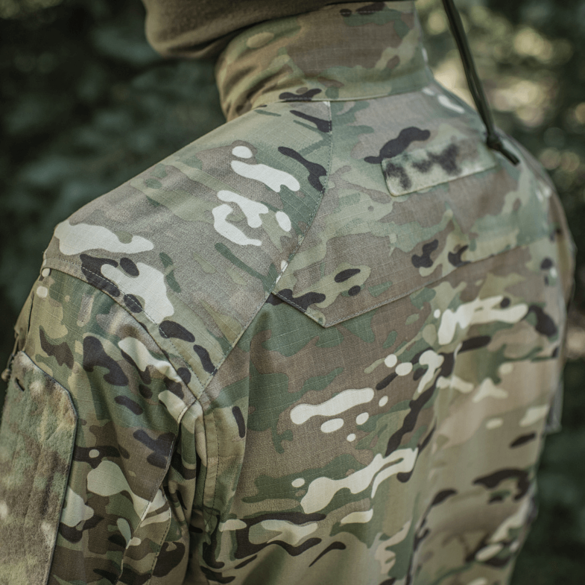 M-Tac-takki Sturm Gen.II NYCO Extreme Multicam-kuvioinnilla ja NIR-teknologialla, takaa kuvattuna ulkoilmassa.