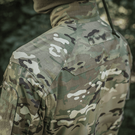 M-Tac-takki Sturm Gen.II NYCO Extreme Multicam-kuvioinnilla ja NIR-teknologialla, takaa kuvattuna ulkoilmassa.