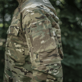 M-Tac-takki Sturm Gen.II NYCO Extreme Multicam, sivulta kuvattuna näkyvine taskuineen, sopii taktisiin ja ulkoilutoimiin.