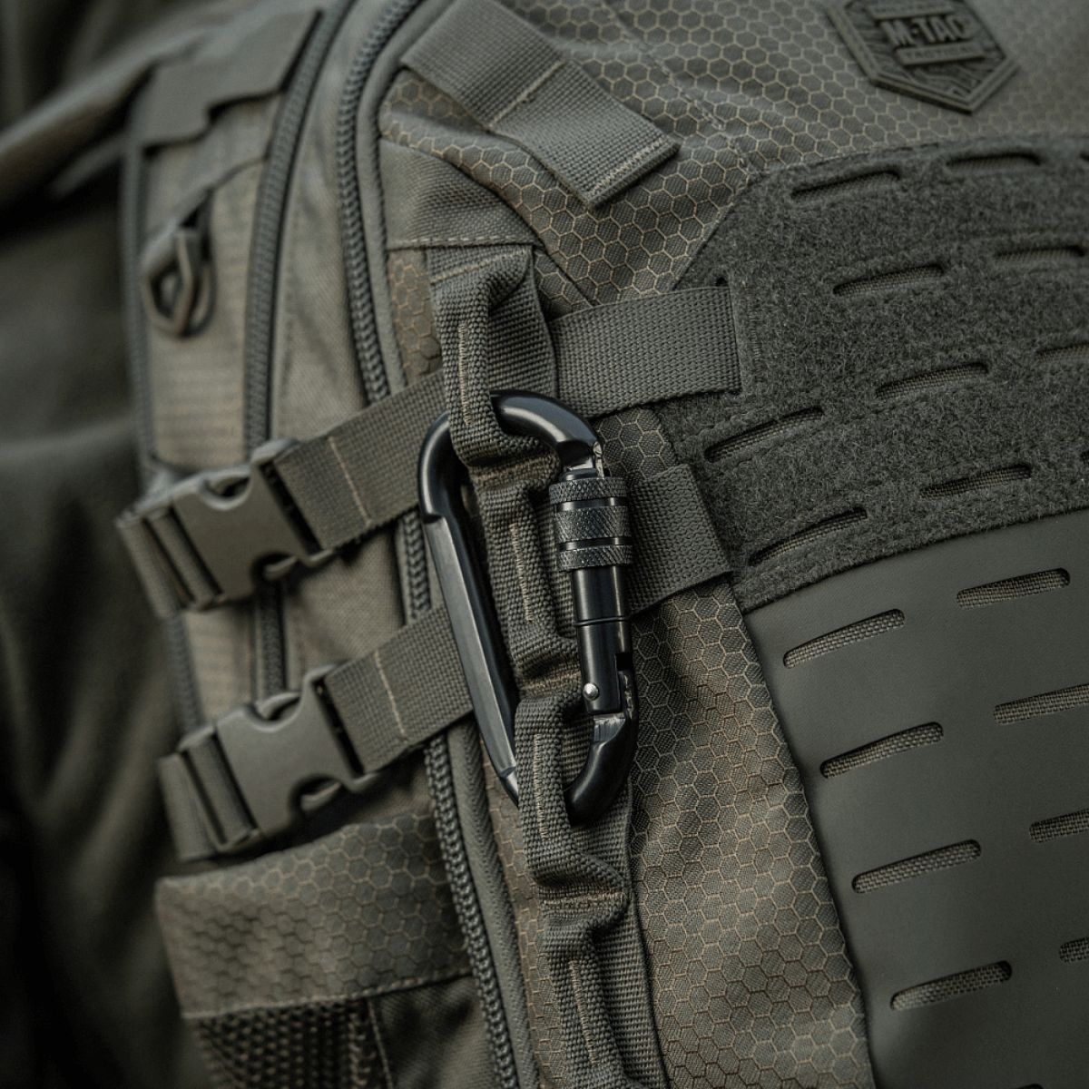 M-Tac karabiinihaka 10 cm kiinnitettynä reppuun, valmistettu 40cr-seosteräksestä, sopiva köysille ja lenkeille.