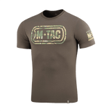 M-Tac T-Shirt Logo camokuvioinnilla, ikoninen M-Tac-logo ja "Born by Revolution – Hardened by War" -slogan hihassa.