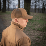 Mies käyttää M-Tac Mesh Flex Ripstop Baseball Capia metsässä; näkyvillä kypärän mesh-paneelit ja kestävä lippa.