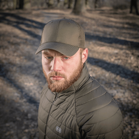 Mies käyttää M-Tac Mesh Flex Ripstop Baseball Cap en metsäympäristössä, käytännöllinen ulkokäyttöön.
