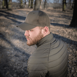 Mies metsässä käyttää M-Tac Mesh Flex Ripstop Baseball Capia; korostaa kestävyyttä ja ilmanvaihtoa ulko-olosuhteissa.