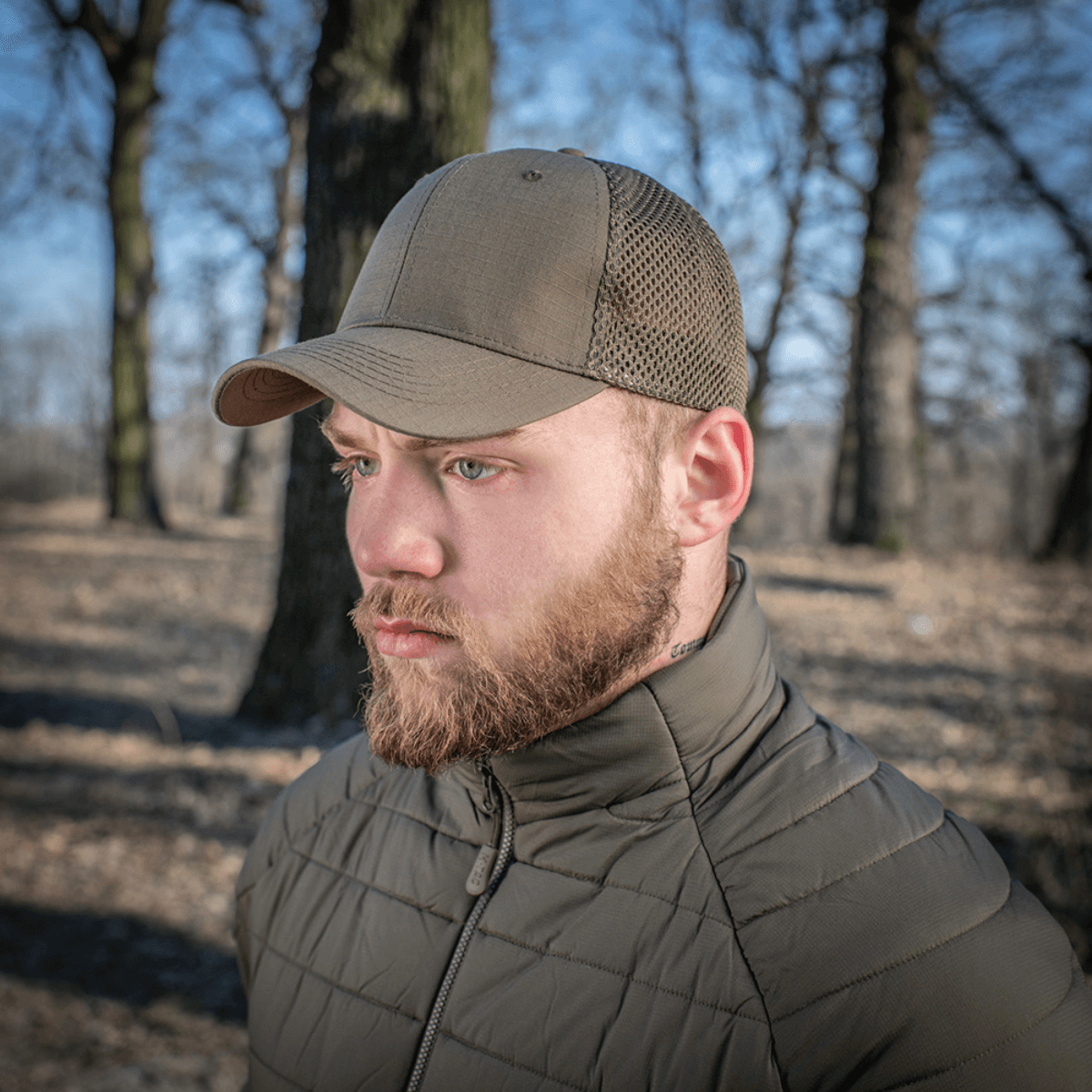 Mies käyttää M-Tac Mesh Flex Ripstop Baseball Capia luonnossa; näkyvillä mesh-paneelit ja kestävä lippa, sopii ulkokäyttöön.